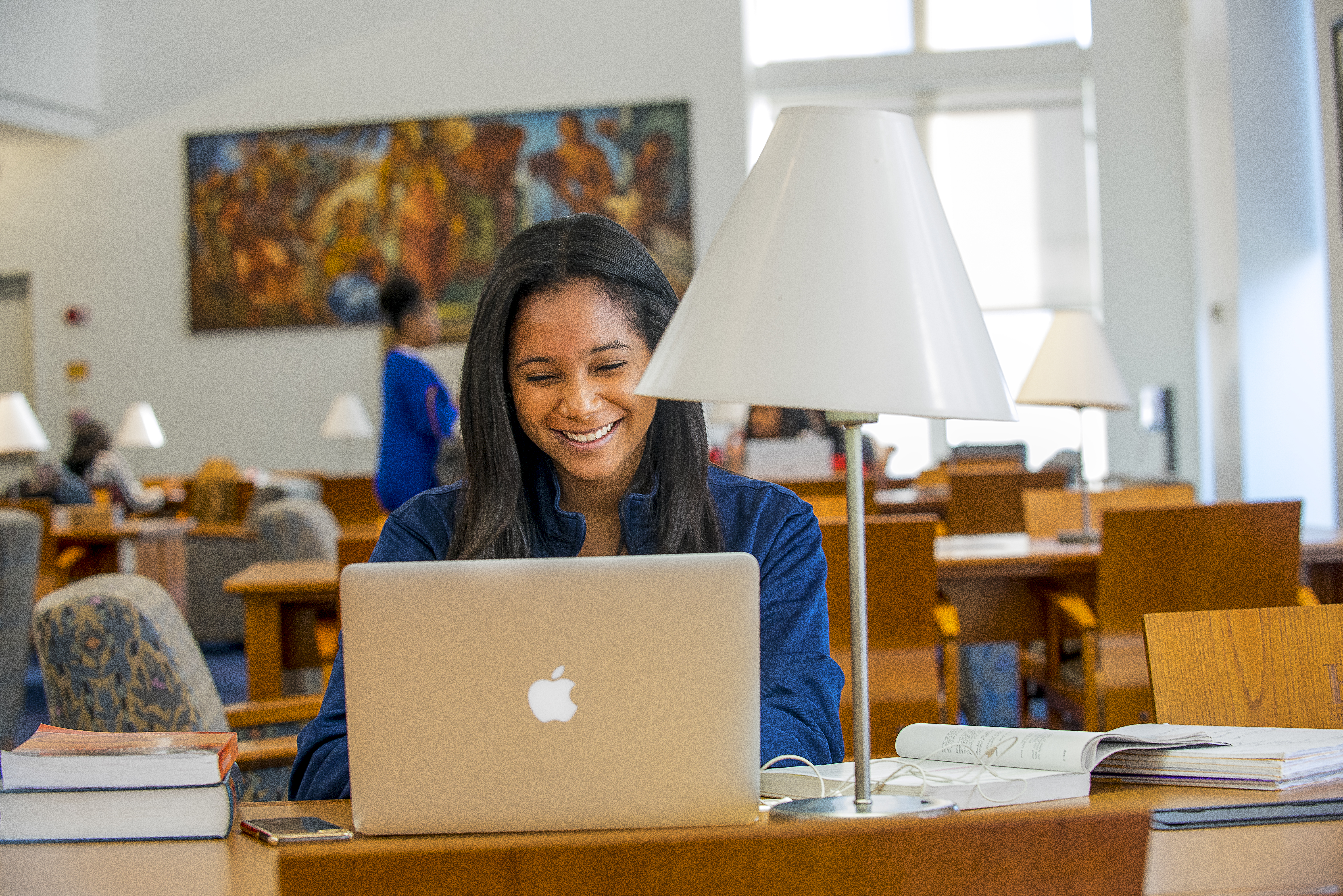 Howard student working on her laptop in the library